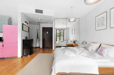 a bedroom with a white bed and a pink dresser at plac Na Groblach 5 by Homeprime in Kraków