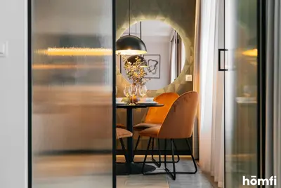 a dining room with a table and chairs and a mirror at Smolensk Loft Suite - homfi Collection in Kraków