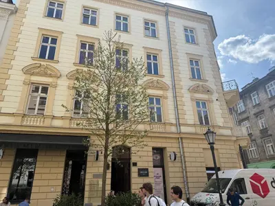 a building with people walking in front of it at Krupnicza 12 in Kraków