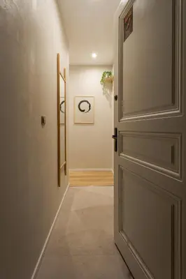 a hallway with an open door and a hallway with a stairway at Krupnicza 12 in Kraków