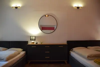 a bedroom with two beds and a mirror on the wall at Apartment Tomasza 8 in Kraków