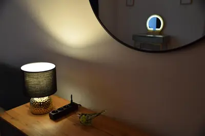 a table with a lamp and a mirror on it at Apartment Tomasza 8 in Kraków