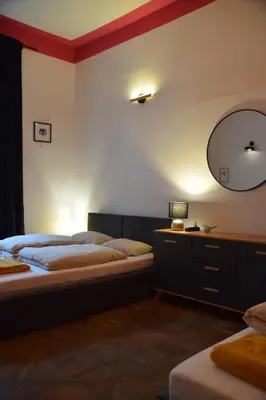 a bedroom with two beds and a mirror on the wall at Apartment Tomasza 8 in Kraków