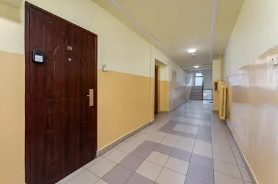 a hallway with a large wooden door and a tile floor at Odrzańska Urban Jungle Apartment by BookingHost in Kraków