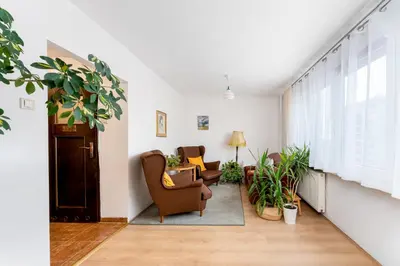 a living room with two chairs and plants at Odrzańska Urban Jungle Apartment by BookingHost in Kraków