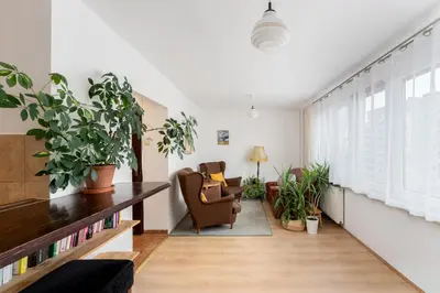 a living room with a large window and plants at Odrzańska Urban Jungle Apartment by BookingHost in Kraków