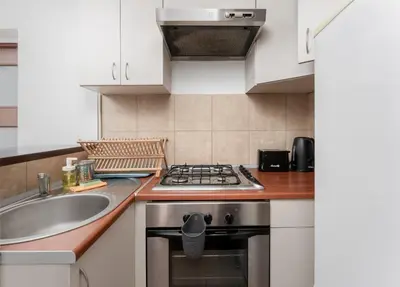 a kitchen with a sink and a stove at Odrzańska Urban Jungle Apartment by BookingHost in Kraków