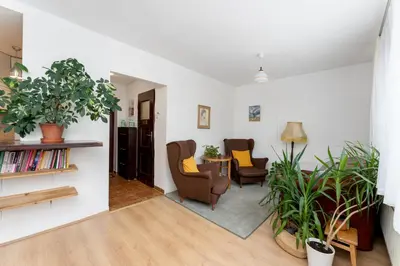 a living room with two chairs and a table at Odrzańska Urban Jungle Apartment by BookingHost in Kraków