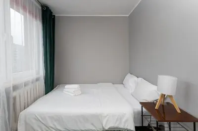 a bedroom with a bed and a table with a lamp at Odrzańska Urban Jungle Apartment by BookingHost in Kraków