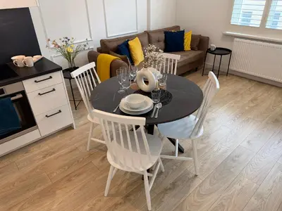 a couch with yellow and blue pillows and a table at Rakowicka Krakow City Center Premium Apartment with Balcony near Main Station in Kraków