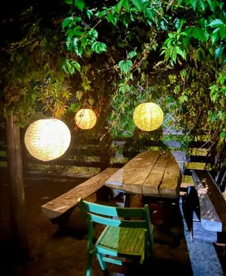 a wooden table with lanterns and a green chair at Domek na szlaku 70 in Skomielna Biała