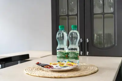 two bottles of soda sitting on a plate on a kitchen counter at Podgórze Pleasant Apartment by BookingHost in Kraków