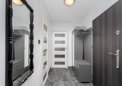 a hallway with a mirror and a walk in closet at Podgórze Pleasant Apartment by BookingHost in Kraków