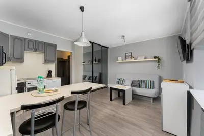 a kitchen and living room with a table and chairs at Podgórze Pleasant Apartment by BookingHost in Kraków