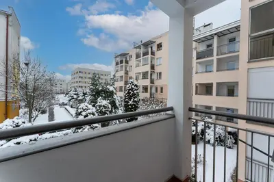 a balcony with snow covered trees and buildings at Podgórze Pleasant Apartment by BookingHost in Kraków