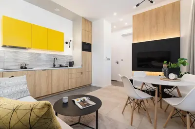 a living room with a table and a kitchen at Apartamenty EN Zator in Podolsze