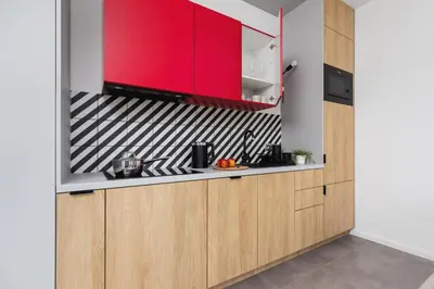 a kitchen with red cabinets and a counter top at Apartamenty EN Zator in Podolsze