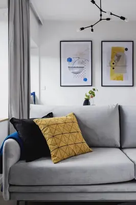 a living room with a gray couch with a yellow pillow at Apartamenty EN Zator in Podolsze