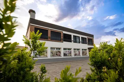 a large white building with windows on the side at Apartamenty EN Zator in Podolsze