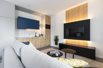 a living room with a white couch and a tv at Apartamenty EN Zator in Podolsze