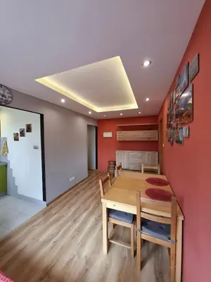 a dining room with a wooden table and red walls at Mieszkanie na Jurze Południowej pod Krakowem in Krzeszowice