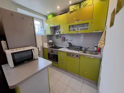 a small kitchen with yellow cabinets and a microwave at Mieszkanie na Jurze Południowej pod Krakowem in Krzeszowice
