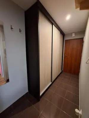 a hallway with wooden doors and a tile floor at Mieszkanie na Jurze Południowej pod Krakowem in Krzeszowice