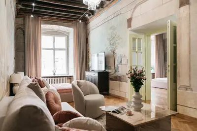 a living room with a couch and a chandelier at Fresco Residence by Tyzenhauz in Kraków