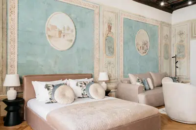 a bedroom with a bed and a wall with paintings at Fresco Residence by Tyzenhauz in Kraków