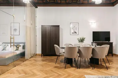 a dining room table with a vase of flowers on it at Fresco Residence by Tyzenhauz in Kraków
