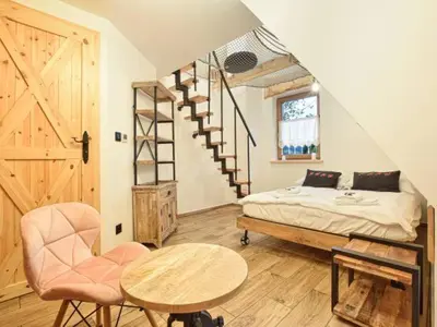 a bedroom with a bed and a staircase and a table at Zawoja domek do wynajęcia in Zawoja