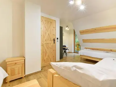 a bedroom with a bed and a wooden door at Zawoja domek do wynajęcia in Zawoja