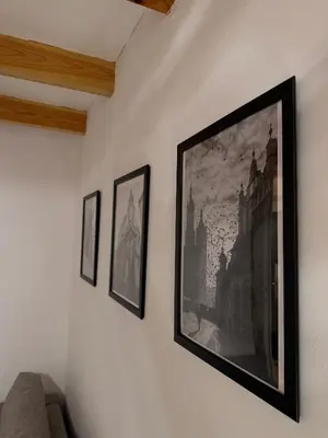 a television hanging on a wall with three pictures at Meiselsa Residence in Kraków