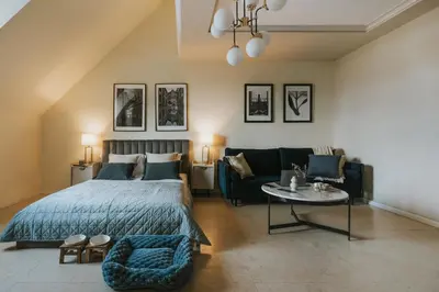 a bedroom with a bed and a couch and a table at Bogoria House in Kraków