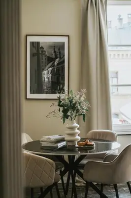 a dining room table with a vase of flowers on it at Bogoria House in Kraków