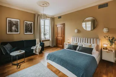 a bedroom with a bed and a couch and a mirror at Bogoria House in Kraków