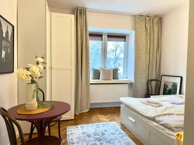 a bedroom with a bed and a table and a window at Premium Studio - Free Parking - Near Old Town in Kraków