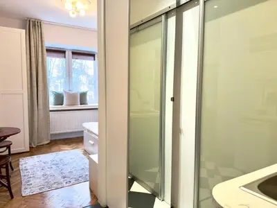 a glass shower door in a bathroom with a sink at Premium Studio - Free Parking - Near Old Town in Kraków