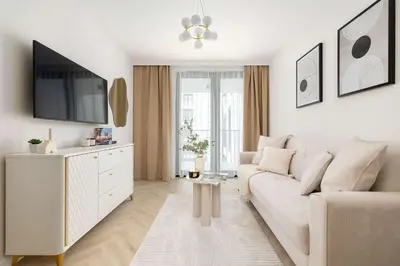 a white living room with a couch and a tv at Stylowy Klimatyzowany Apartment Blisko Tauron Areny by Noclegi Renters in Kraków
