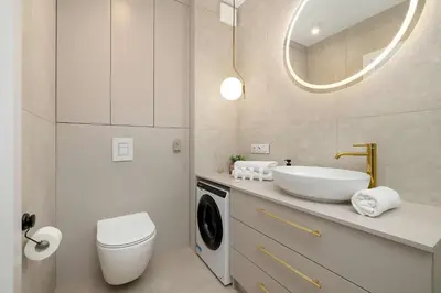 a bathroom with a sink and a washing machine at Stylowy Klimatyzowany Apartment Blisko Tauron Areny by Noclegi Renters in Kraków