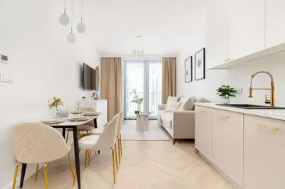 a kitchen and living room with a table and chairs at Stylowy Klimatyzowany Apartment Blisko Tauron Areny by Noclegi Renters in Kraków