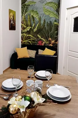 a table with plates and glasses on top of it at Cozy Old Town Apartments in Kraków