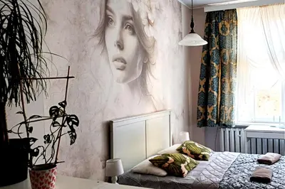 a bedroom with a poster of a woman on the wall at Cozy Old Town Apartments in Kraków