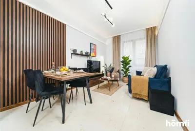 a living room with a bed and a dining room at Smolensk Concept Residence - homfi Collection in Kraków
