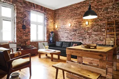 a living room with a couch and a brick wall at Loft Apartment Industrial Design in Kraków