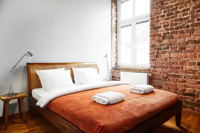 a bedroom with a bed with two towels on it at Loft Apartment Industrial Design in Kraków