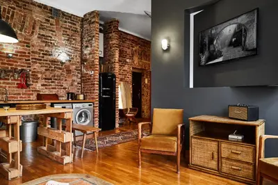 a living room with a brick wall and a table and chairs at Loft Apartment Industrial Design in Kraków
