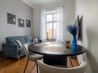 a living room with a table and a couch at Apartament Mostowa in Kraków