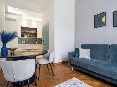 a bathroom with a sink and a mirror and a shower at Apartament Mostowa in Kraków