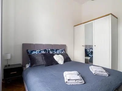 a white kitchen with white cabinets and appliances at Apartament Mostowa in Kraków
